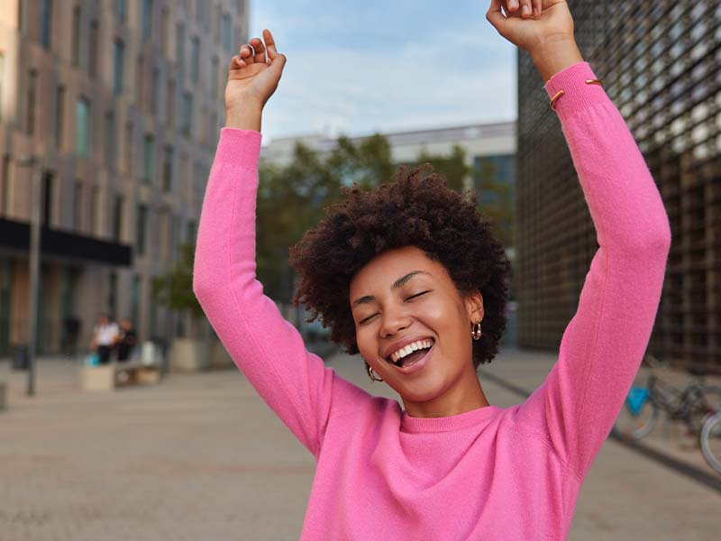 Woman smiling with her hands near her jaw